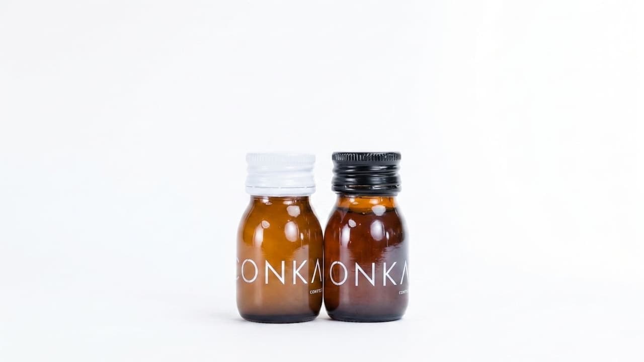 Two CONKA bottles: Flow with a white cap and Clear with a black cap