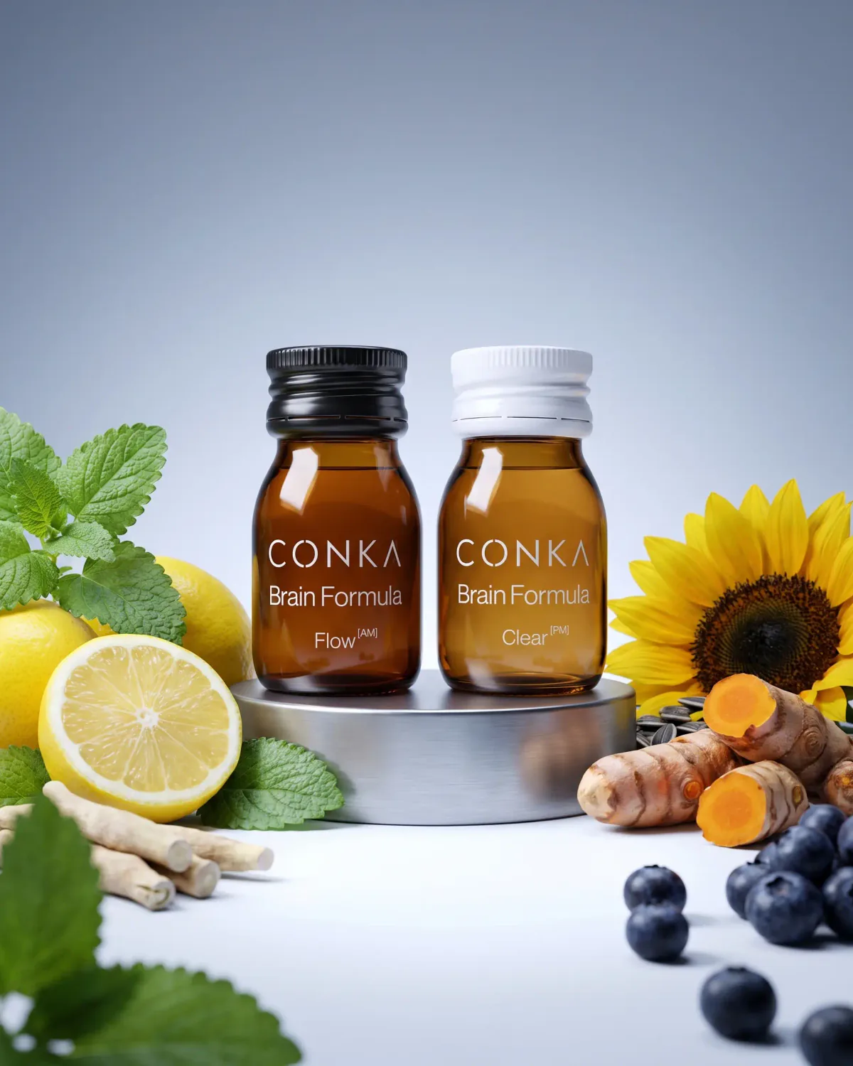 CONKA Flow and Clear shots on a steel plinth, surrounded by lemon balm, citrus, turmeric root, blueberries and sunflower