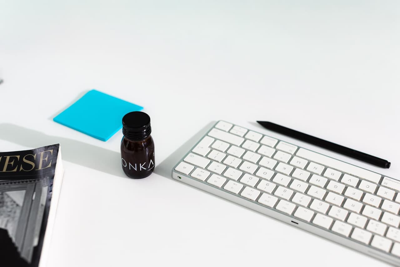 CONKA Flow bottle on a desk next to a keyboard, pen, notebook and sticky note